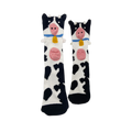 Black and white spotted socks with a cow face at the top, featuring a 3D pink snout, sticking-out ears, and a yellow bell.