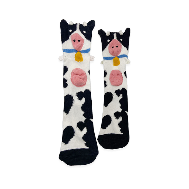 Black and white spotted socks with a cow face at the top, featuring a 3D pink snout, sticking-out ears, and a yellow bell.