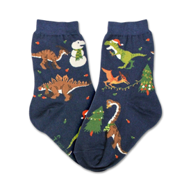 kids christmas tree rex crew socks in dark blue feature holiday dinosaurs in santa hats and christmas lights surrounded by trees and snowflakes.   