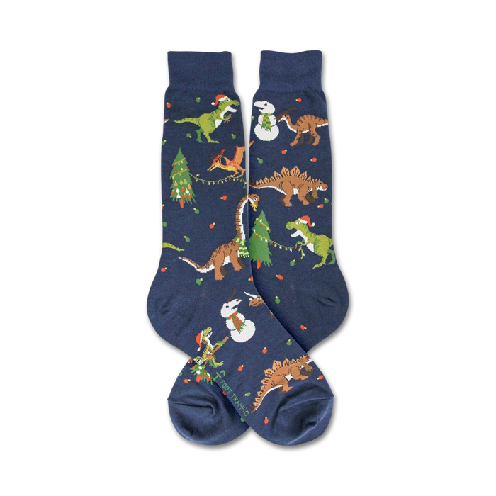A pair of blue socks with a pattern of dinosaurs, Christmas trees, and snowmen.