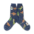 A pair of navy blue crew socks showcasing a whimsical Christmas design. The socks feature various dinosaurs wearing Santa hats and celebrating around decorated Christmas trees and snowmen.