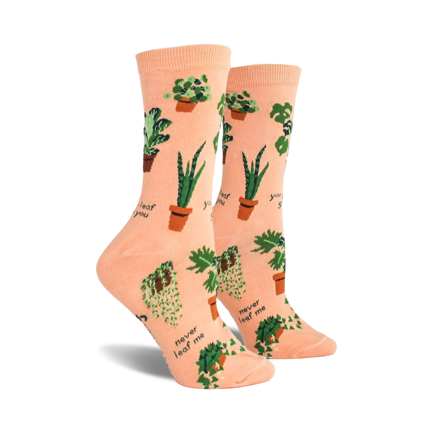 A pair of peach-colored crew socks with a fun pattern of potted plants and plant puns like 'Never leaf me'.