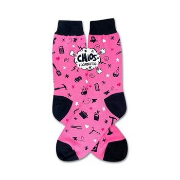 pink crew socks feature black toes and heels, repeating patterns of clothes irons, scissors, measuring tape, and a hanger. "chaos coordinator" displayed on one sock in speech bubble.  