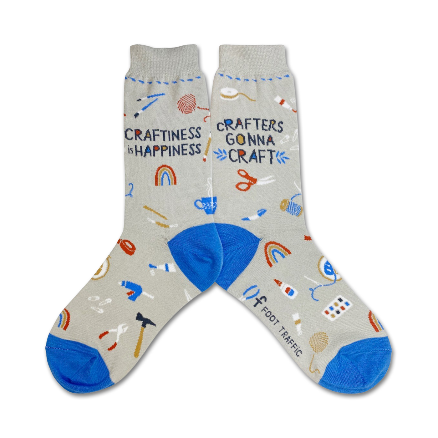 A pair of gray crew socks with blue cuffs.  The socks are decorated with colorful illustrations of crafting tools and the text 'Craftiness is Happiness' and 'Crafters Gonna Craft'.