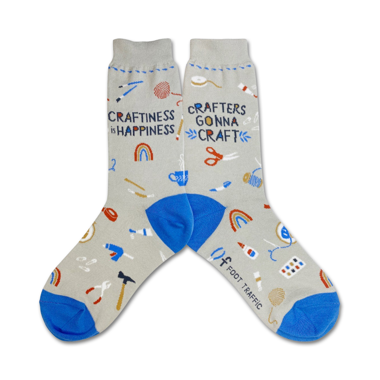 A pair of gray crew socks with blue cuffs.  The socks are decorated with colorful illustrations of crafting tools and the text 'Craftiness is Happiness' and 'Crafters Gonna Craft'.