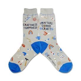 gray crew socks with blue toes, heels, and cuffs. pattern of multicolored crafting supplies, including scissors, tape measures, yarn, and buttons. text "crafiness is happiness" and "crafters gonna craft" knit into socks. womens.   
