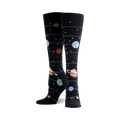 Pair of women's knee-high socks.  Navy blue background with planets (blue, orange, and ringed) and stars in a solar system design.