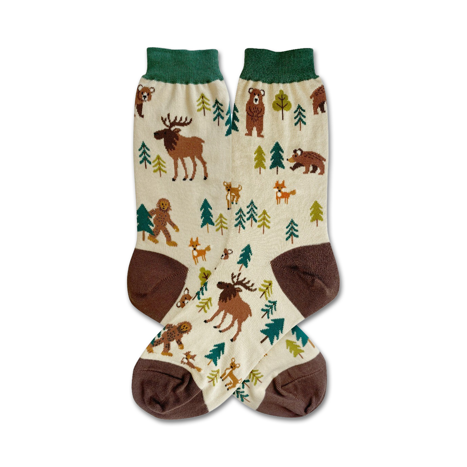 Cream crew socks with brown and green accents. Design features illustrated woodland creatures like moose, bears, Bigfoot, and foxes among stylized evergreen trees.
