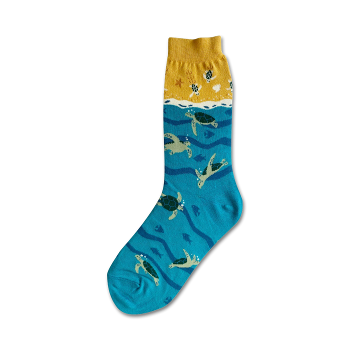green sea turtles swim through a wavy ocean on these blue crew socks designed for women.   }}