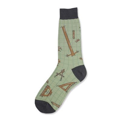 Crew socks in sage green with a pattern of brown architectural tools like rulers, compasses and set squares on a grid background. Dark grey heel and toe.