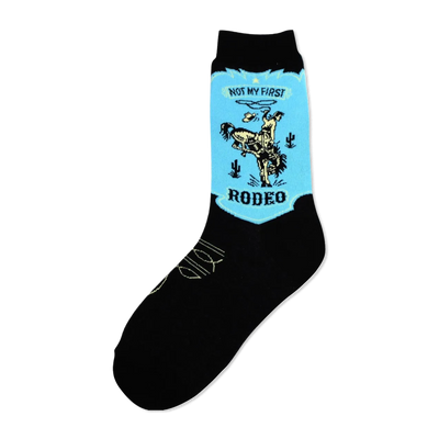 Black crew socks with a light-blue patch showing a vintage-style illustration of a cowboy on a bronco. The words 'Not My First Rodeo' and 'Rodeo' are featured.