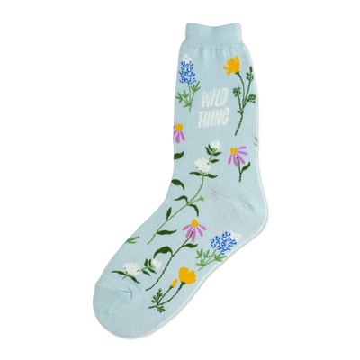 Light blue crew socks adorned with a whimsical pattern of various wildflowers in pink, purple, yellow, and blue, along with the text 'Wild Thing'.