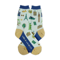Pair of light teal crew socks with navy blue cuffs and gold heels. Features illustrated landmarks, suitcases, and travel icons.