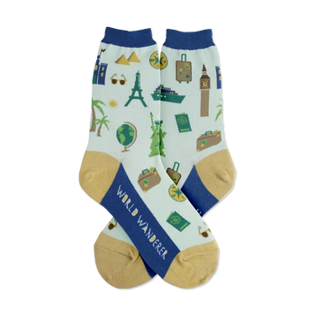 Pair of light teal crew socks with navy blue cuffs and gold heels. Features illustrated landmarks, suitcases, and travel icons.