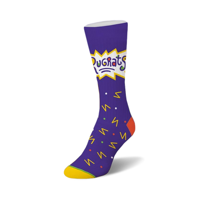 rugrats confetti socks for women. purple with yellow toe and heel. crew length sock features rugrats cartoon characters and shapes in yellow, orange, blue, and green.    