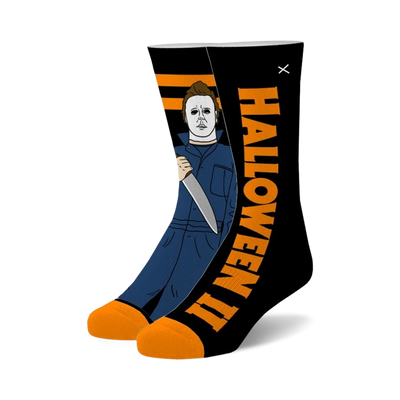 black crew socks with orange toe and heel featuring a pattern of michael myers from the halloween movies.   