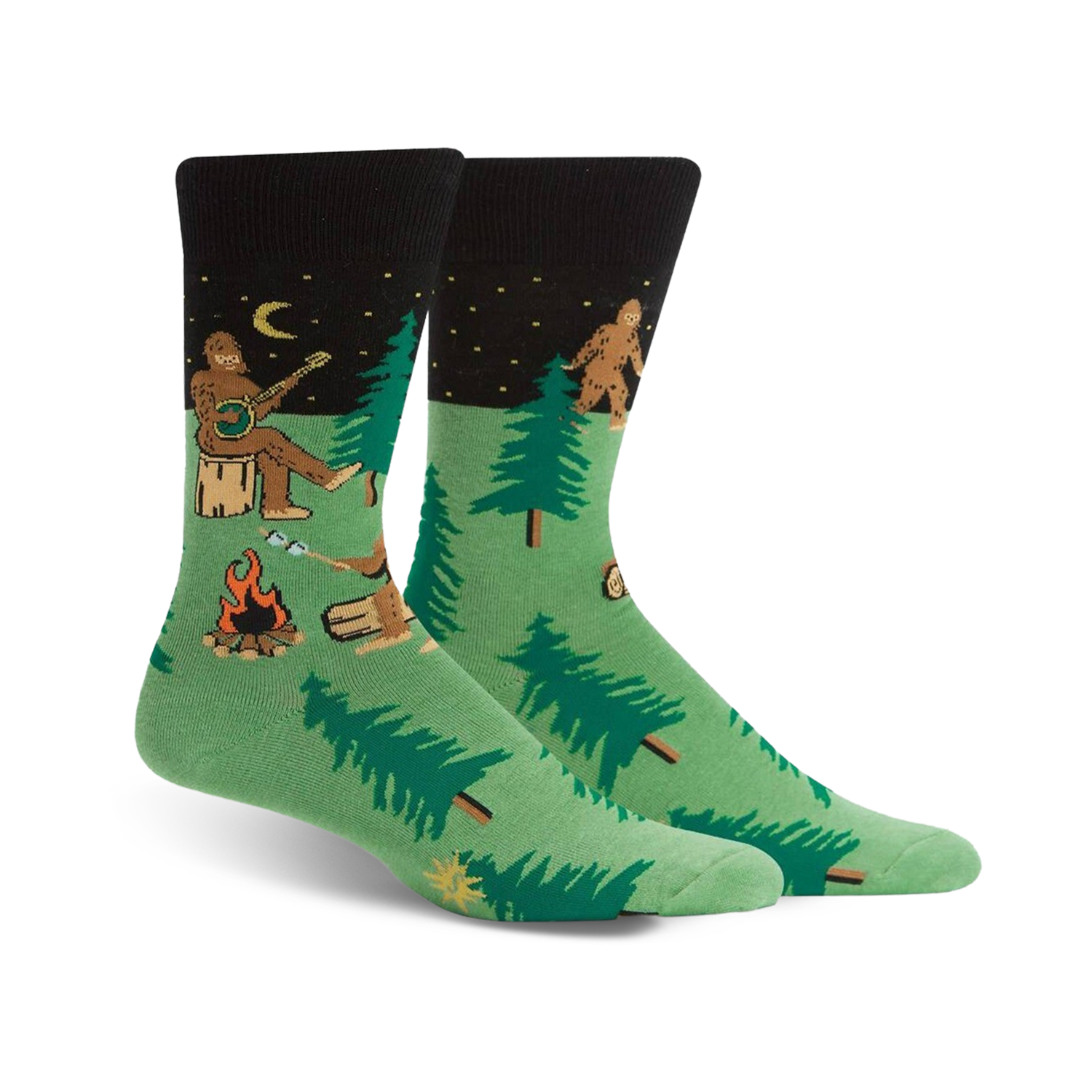 Pair of green and black crew socks featuring a whimsical Sasquatch playing banjo around a campfire in the woods.