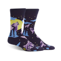Crew socks in dark purple featuring howling wolves silhouetted against a yellow moon and light blue pine trees. Stars and other wolves decorate the background.