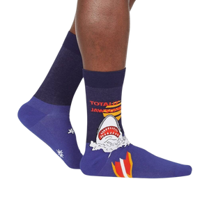 A pair of blue socks with a shark graphic on the left sock and the words 