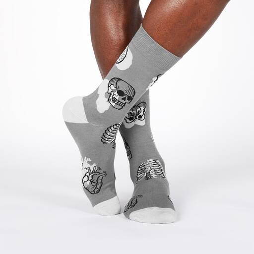 A pair of gray socks with a pattern of brains, hands, and skulls.