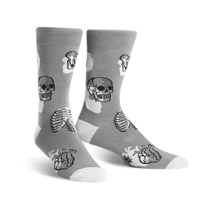 mens crew-length gray socks feature a pattern of black and white skulls, rib cages, and hearts. 