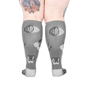 Back view of the anatomical socks on a model's legs.  Shows the full design of the socks, including brains and pelvis bones.