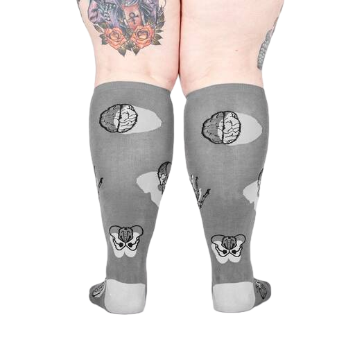 Back view of the anatomical socks on a model's legs.  Shows the full design of the socks, including brains and pelvis bones.