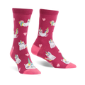 Crew socks in pink featuring a pattern of white cats with unicorn horns and rainbow tails, and pink hearts.