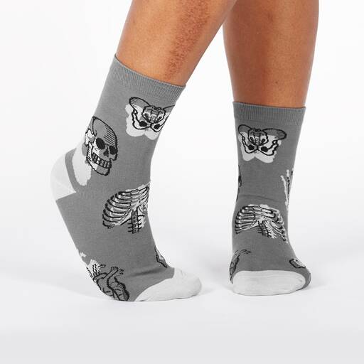 A pair of gray socks with a pattern of brains and skulls.