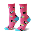 Pair of women's crew socks. Pink background with black cats shooting rainbow lasers and yellow stars. Light blue cuffs.