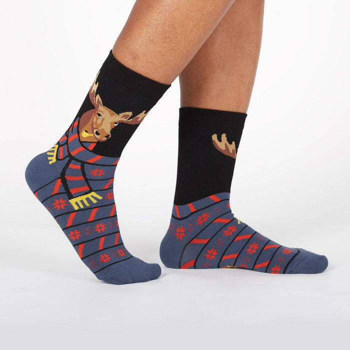 A pair of black and gray socks with a cartoon moose wearing a red and white striped scarf on the back of each sock.