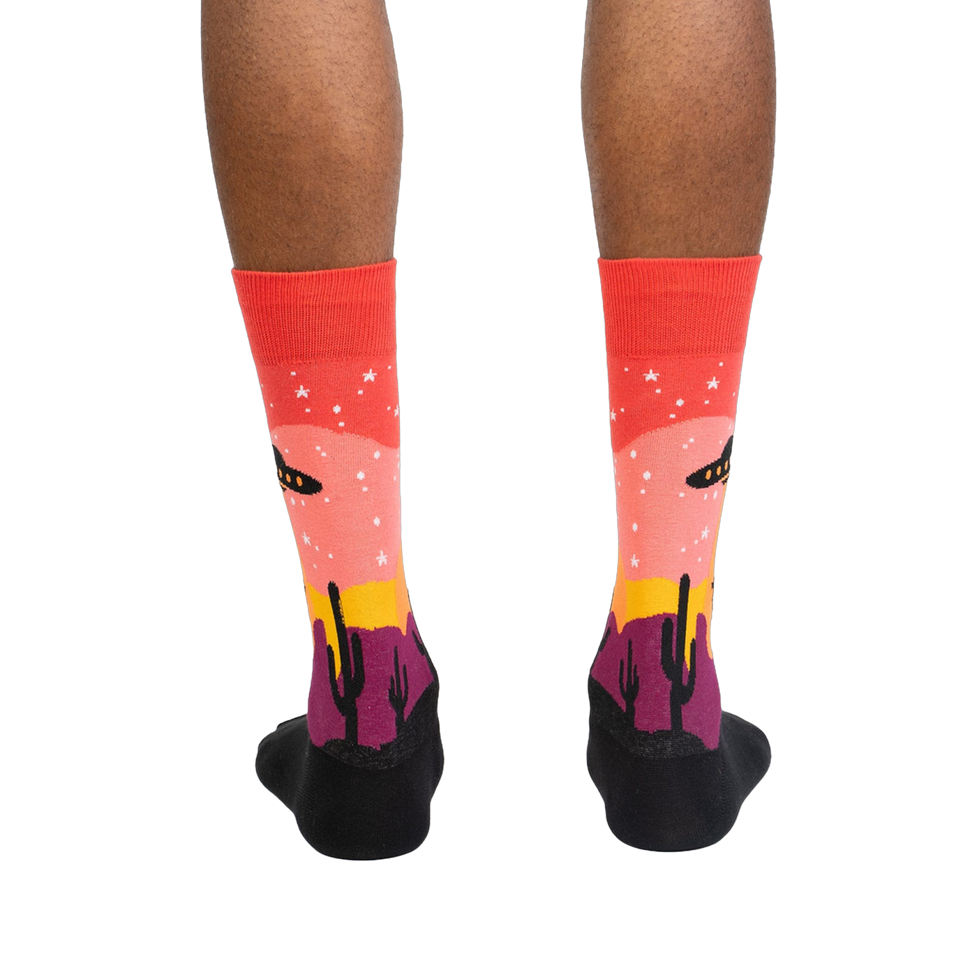 Rear view of a person's legs wearing the Area 51 socks.  The socks' design is fully visible.