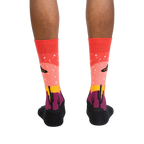 Rear view of a person's legs wearing the Area 51 socks.  The socks' design is fully visible.