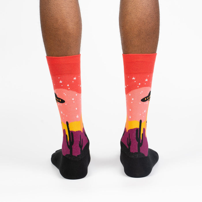 A pair of black and red socks with a UFO and cacti design.