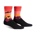 Crew socks in black, red, orange, and purple, featuring a desert sunset scene with a UFO, stars, cacti, and a cow.