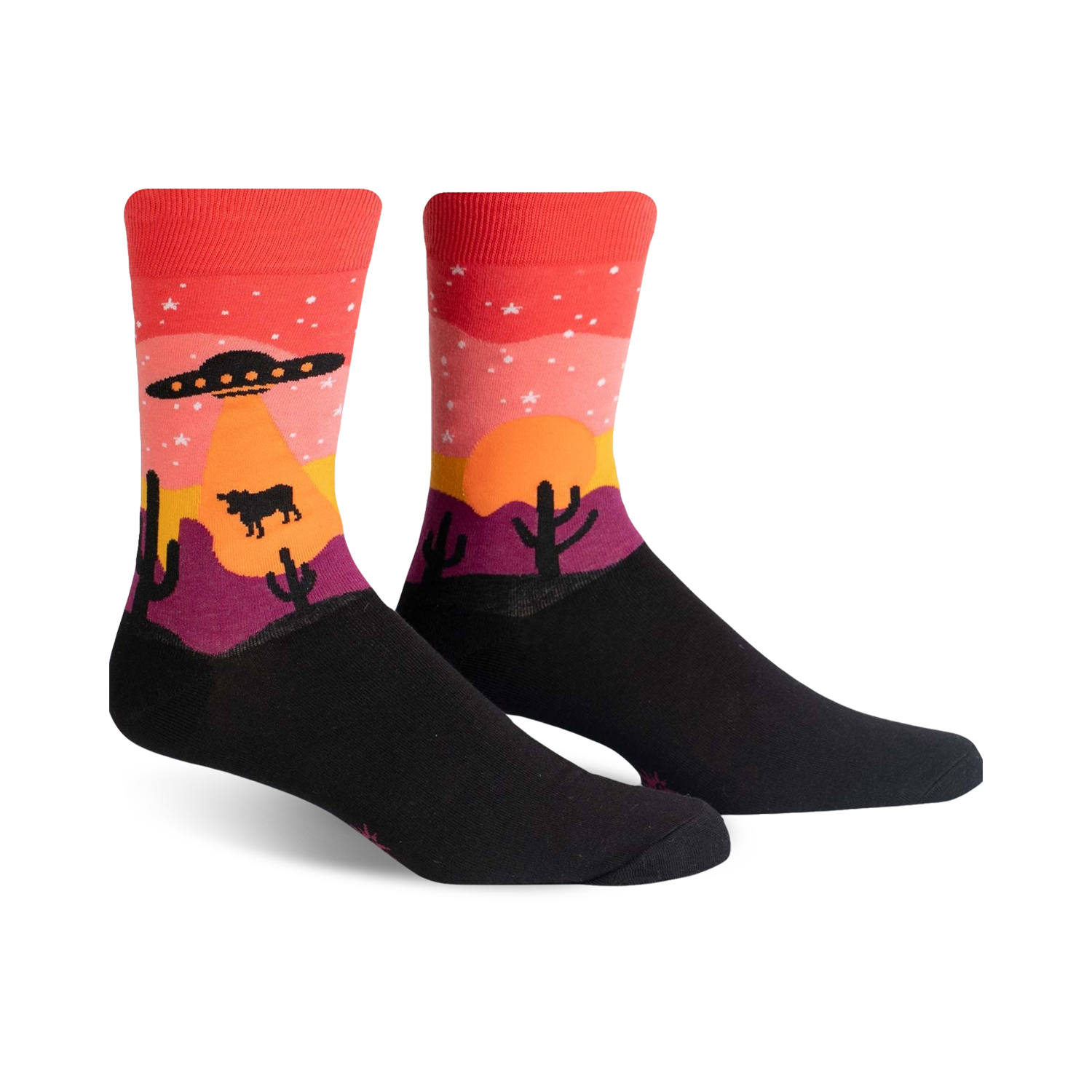 Crew socks in black, red, orange, and purple, featuring a desert sunset scene with a UFO, stars, cacti, and a cow.