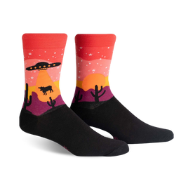area 51 themed novelty socks feature a desert scene with a cow, cacti, flying saucer, and mountain.   