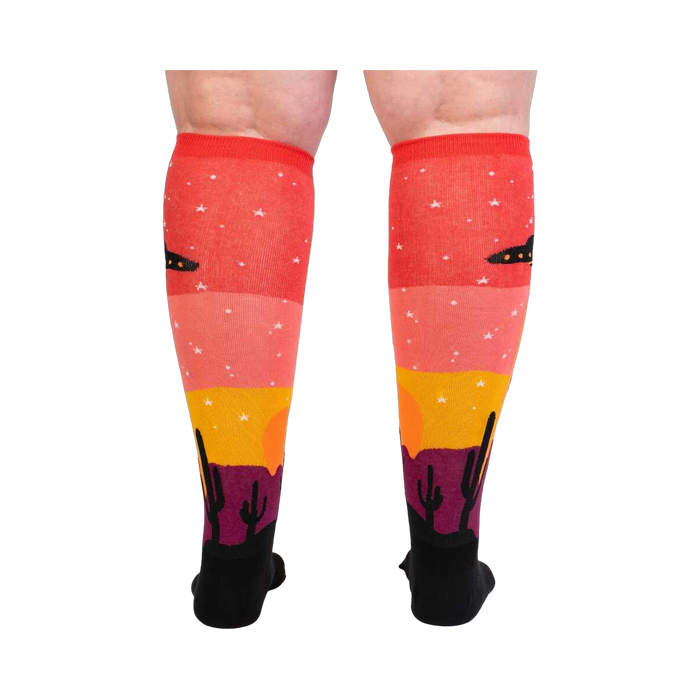 Back view of a person wearing Area 51 socks, showcasing the complete design on both socks.