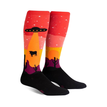 area 51 knee-high socks featuring a ufo, desert, and cow pattern in orange, black, and pink. available for men and women.  