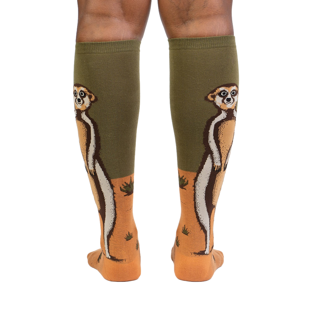 Rear view of a person wearing a pair of Meerkat Manner knee-high socks, showing the full meerkat design on both socks.