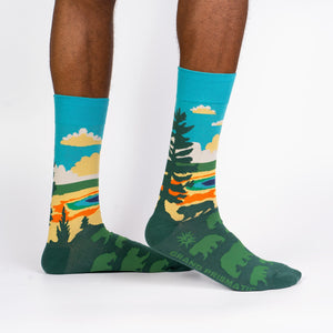 A pair of blue and green socks with a pattern of pine trees on them.