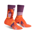A pair of crew socks showcasing Delicate Arch National Park.  The socks are predominantly orange and purple, featuring the arch, a night sky, and dark silhouettes of bobcats.