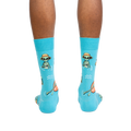 Rear view of a person modeling the turquoise crew socks, showcasing the full alien design.