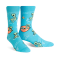 A pair of turquoise crew socks featuring a fun pattern of green aliens relaxing in the water, some on inner tubes. 
