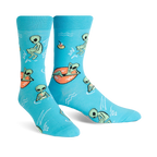 A pair of turquoise crew socks featuring a fun pattern of green aliens relaxing in the water, some on inner tubes. 