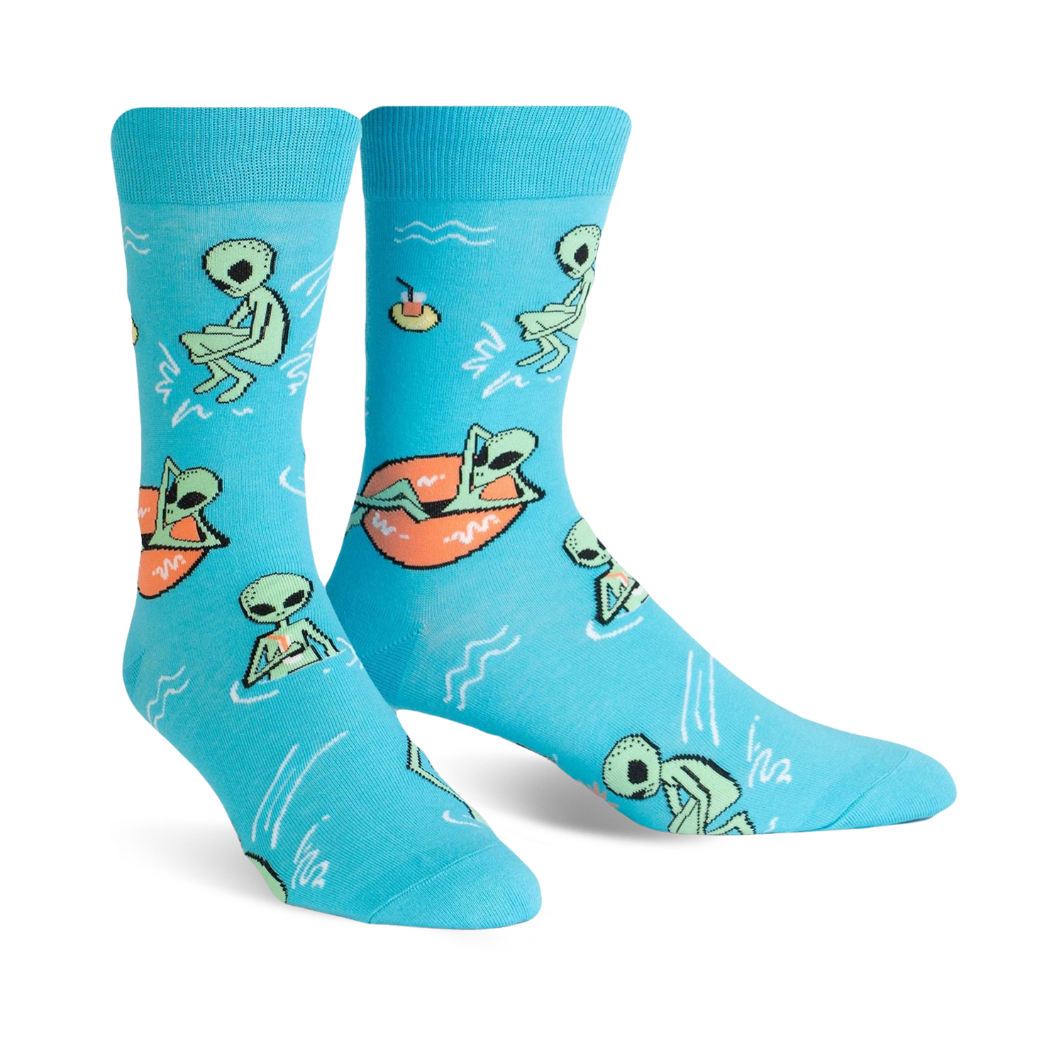 A pair of turquoise crew socks featuring a fun pattern of green aliens relaxing in the water, some on inner tubes. 
