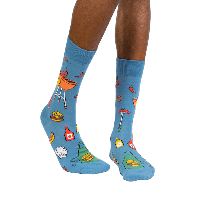 Lifestyle photo showing the 'Grillin' It' socks on a person's legs against a white background.