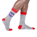A pair of gray crew socks with the NASA logo and white stars. Red accents on the cuffs and toes. Glow in the dark feature.