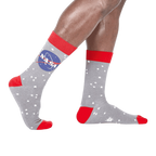 A pair of gray crew socks with the NASA logo and white stars. Red accents on the cuffs and toes. Glow in the dark feature.