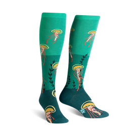 teal knee-high socks with orange jellyfish and yellow tentacle pattern, dark teal toe and heel with green plant accents.   